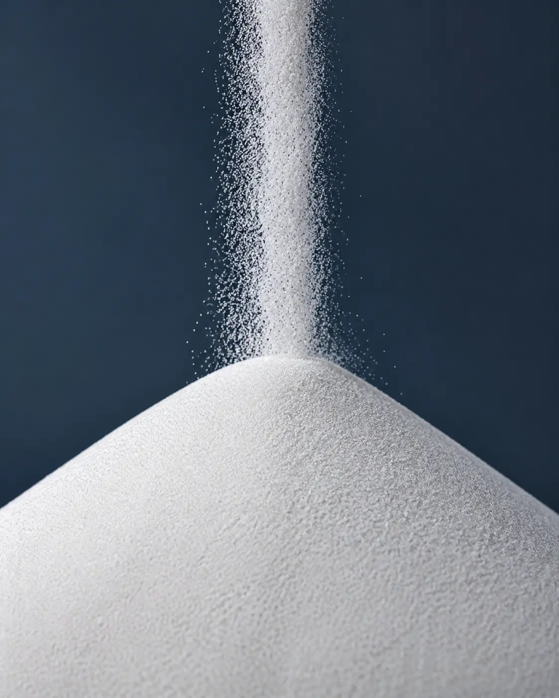 Milky-white crystalline high-purity quartz sand falling into a controlled particle mound